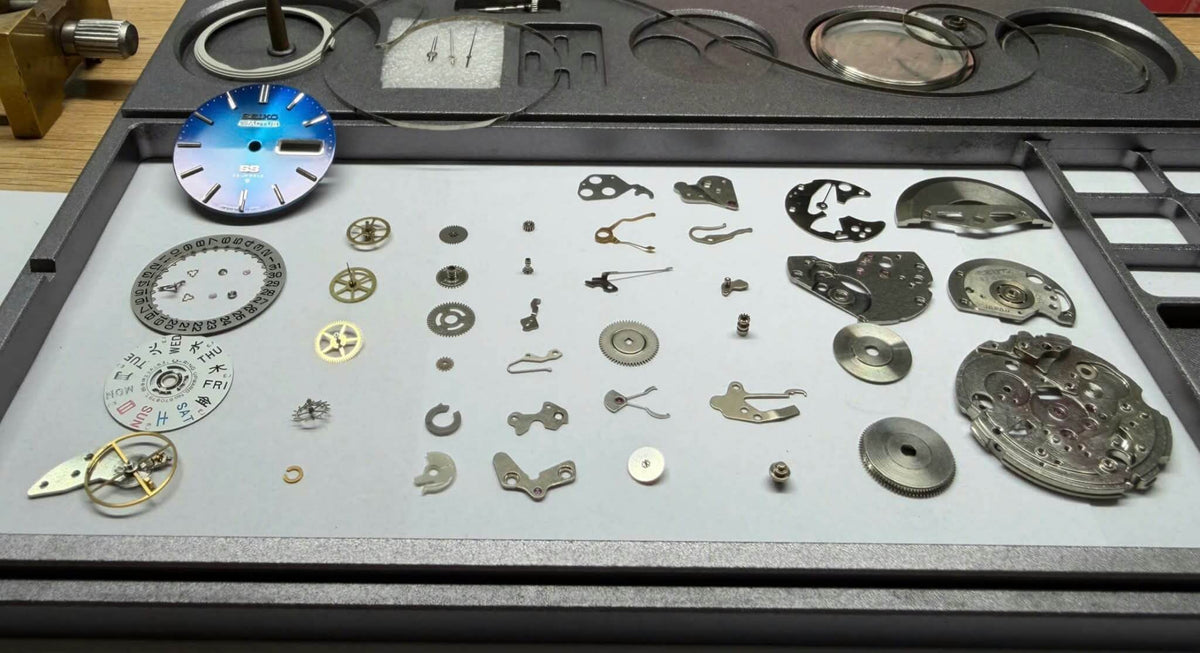 Seiko 5 Actus SS 6106-8670 watch parts and components, including blue dial and mechanical pieces.