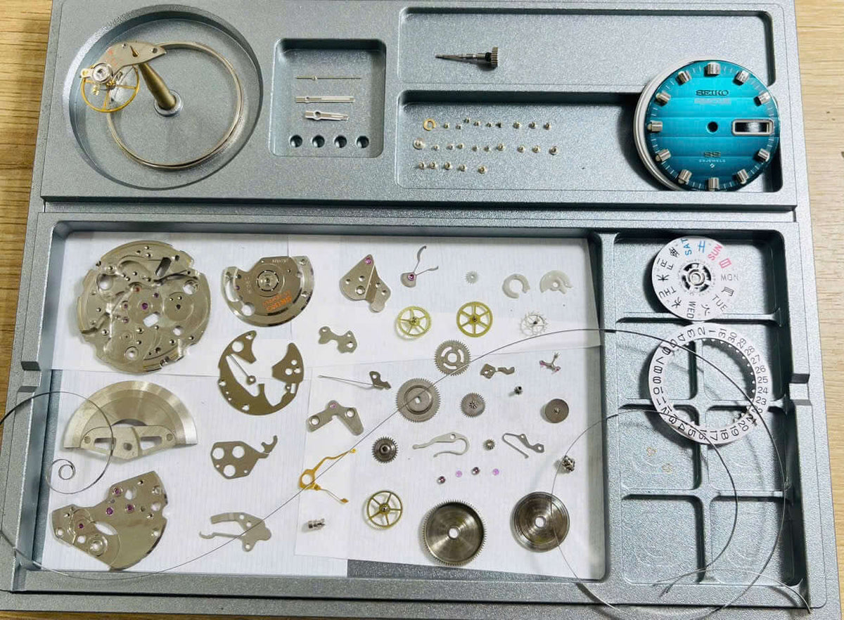 Vintage Seiko 5 Actus 6106-7690 watch parts and components displayed on a tray with rare turquoise dial.