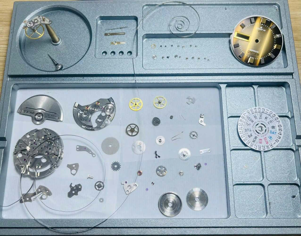 Vintage Seiko Lord Matic 5606-7300 parts and components assembled for servicing and repair on a watchmaker's tray.