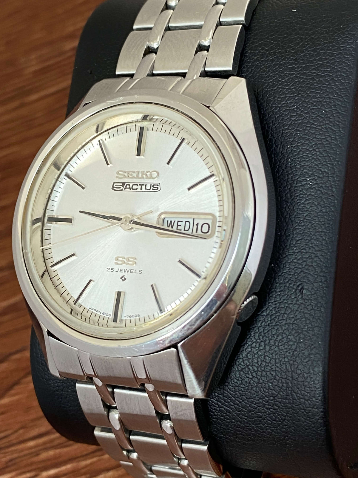 Vintage Seiko 5 SS Actus 6106-7510 on a black display, featuring a white dial and stainless steel bracelet.