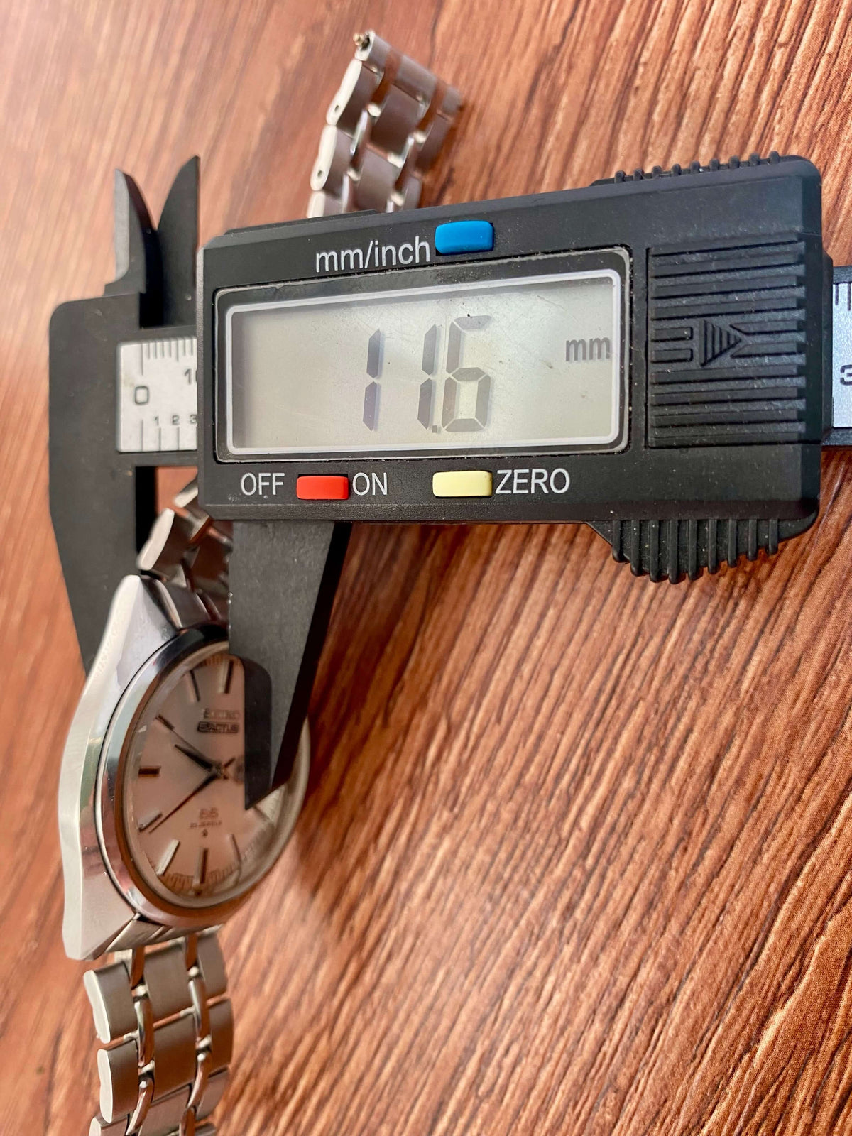 Measuring the Vintage Seiko 5 SS Actus 6106-7510 watch using calipers showing a measurement of 116mm.