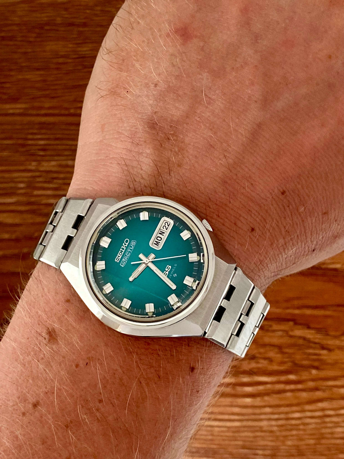 Vintage Seiko 5 Actus 6106-7690 on wrist showcasing rare turquoise dial and stainless steel bracelet.