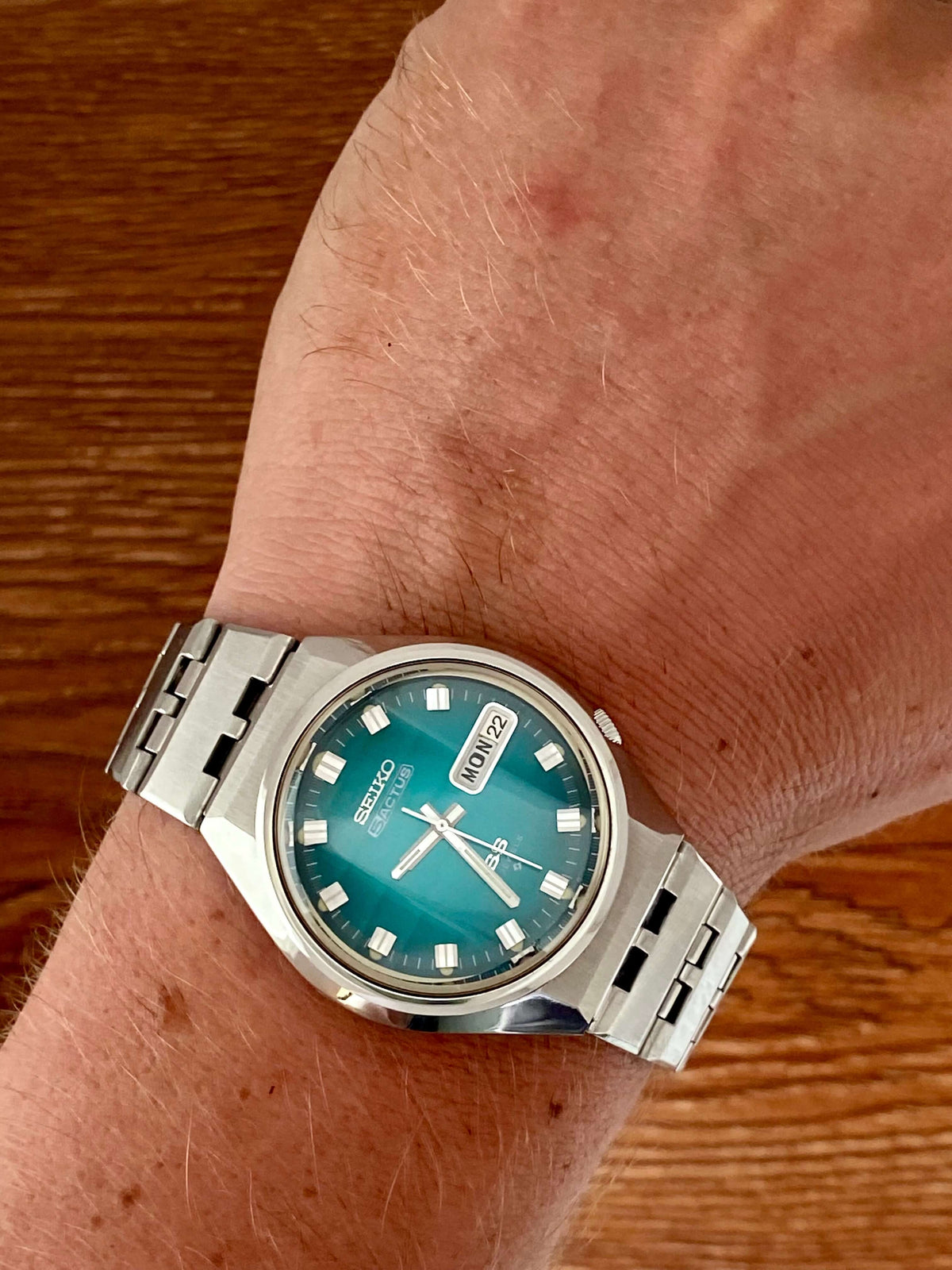 Vintage Seiko 5 Actus 6106-7690 on wrist showcasing the rare turquoise dial and stainless steel case.