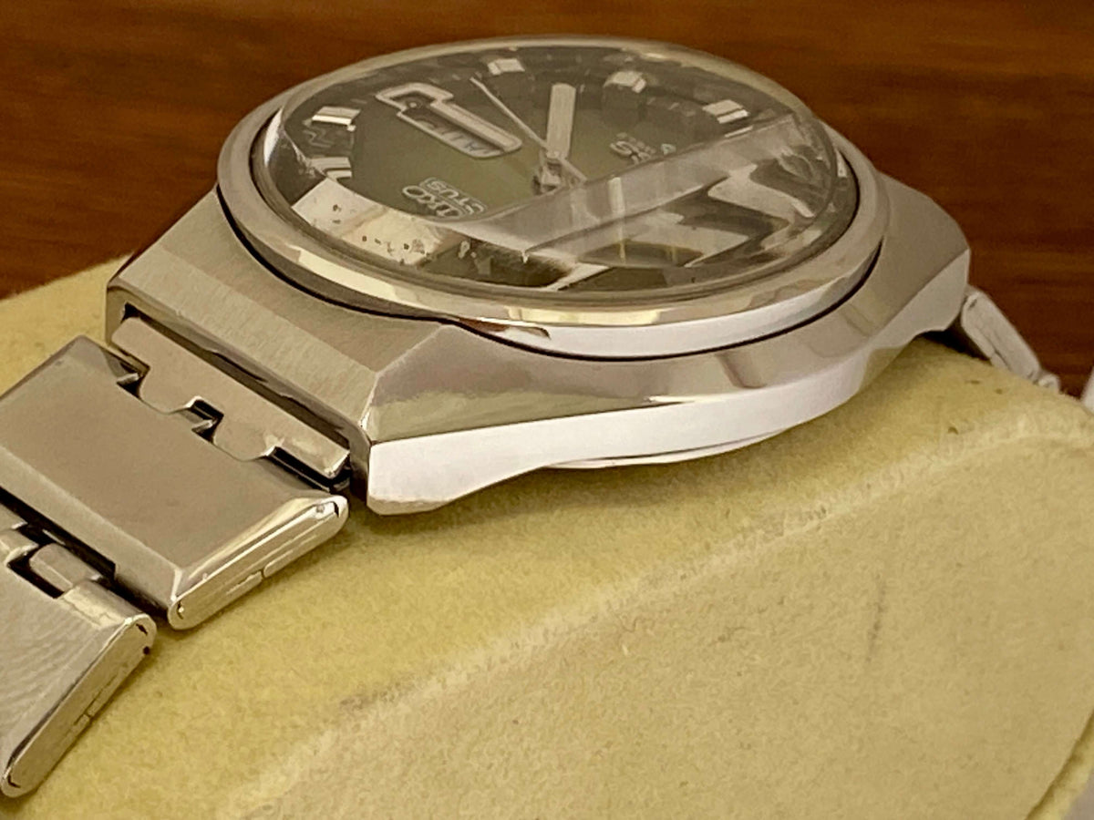 Vintage Seiko 5 Actus 6106-7690 side view showcasing mint condition stainless steel case and original faceted crystal