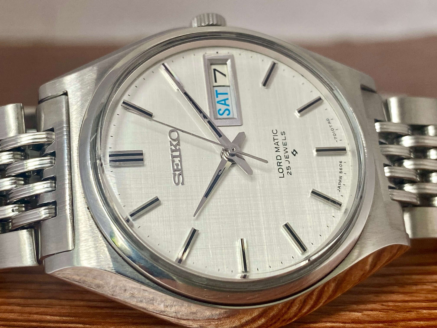 Vintage Seiko Lord Matic 5606-7010 watch with original white linen dial and day-date display.