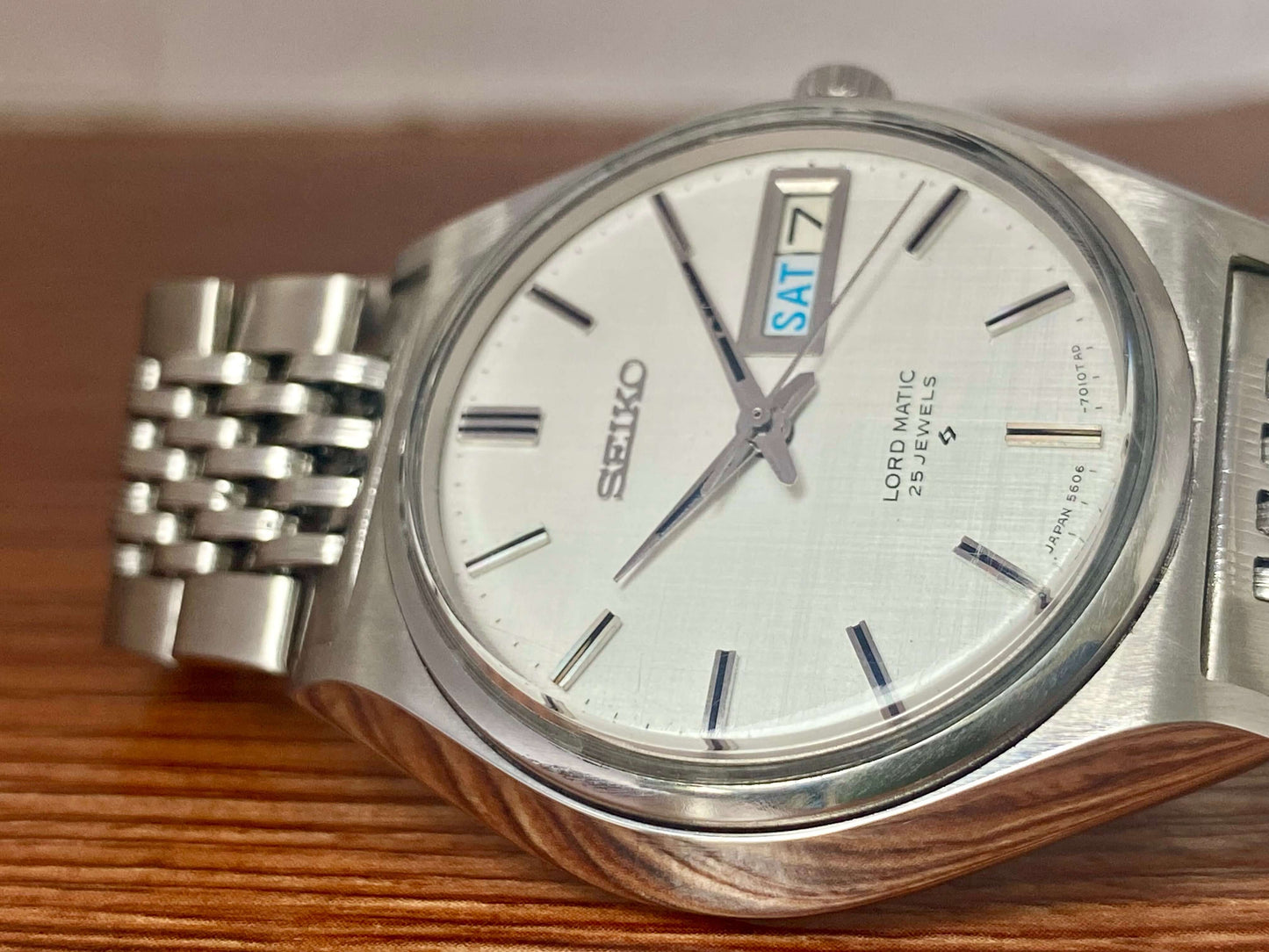 Vintage Seiko Lord Matic 5606-7010 watch with original white linen dial and stainless steel bracelet.