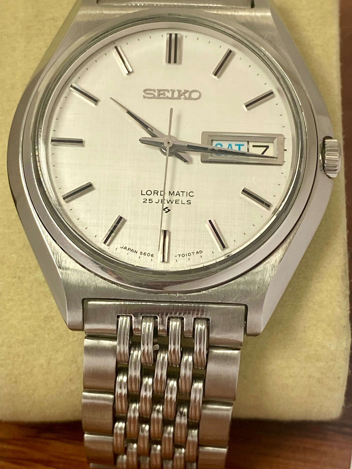 Vintage Seiko Lord Matic 5606-7010 watch with original white linen dial and stainless steel band.