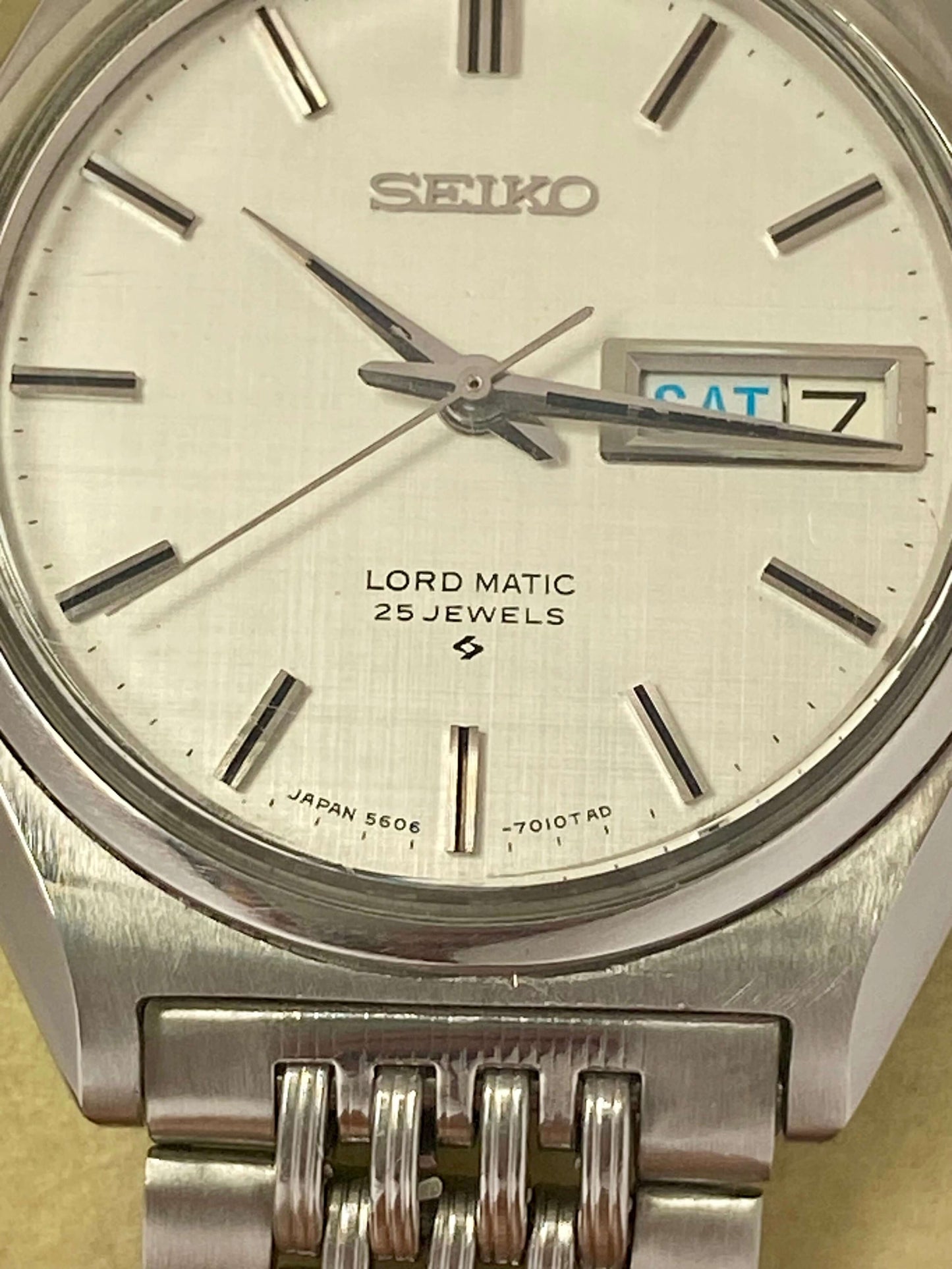 Vintage Seiko Lord Matic 5606-7010 close-up of the original white linen dial and stainless steel case.