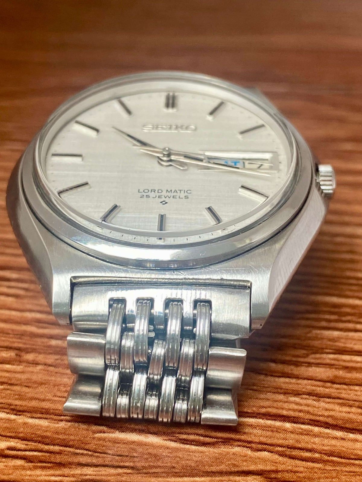 Vintage Seiko Lord Matic 5606-7010 automatic watch with original white linen dial and date function.