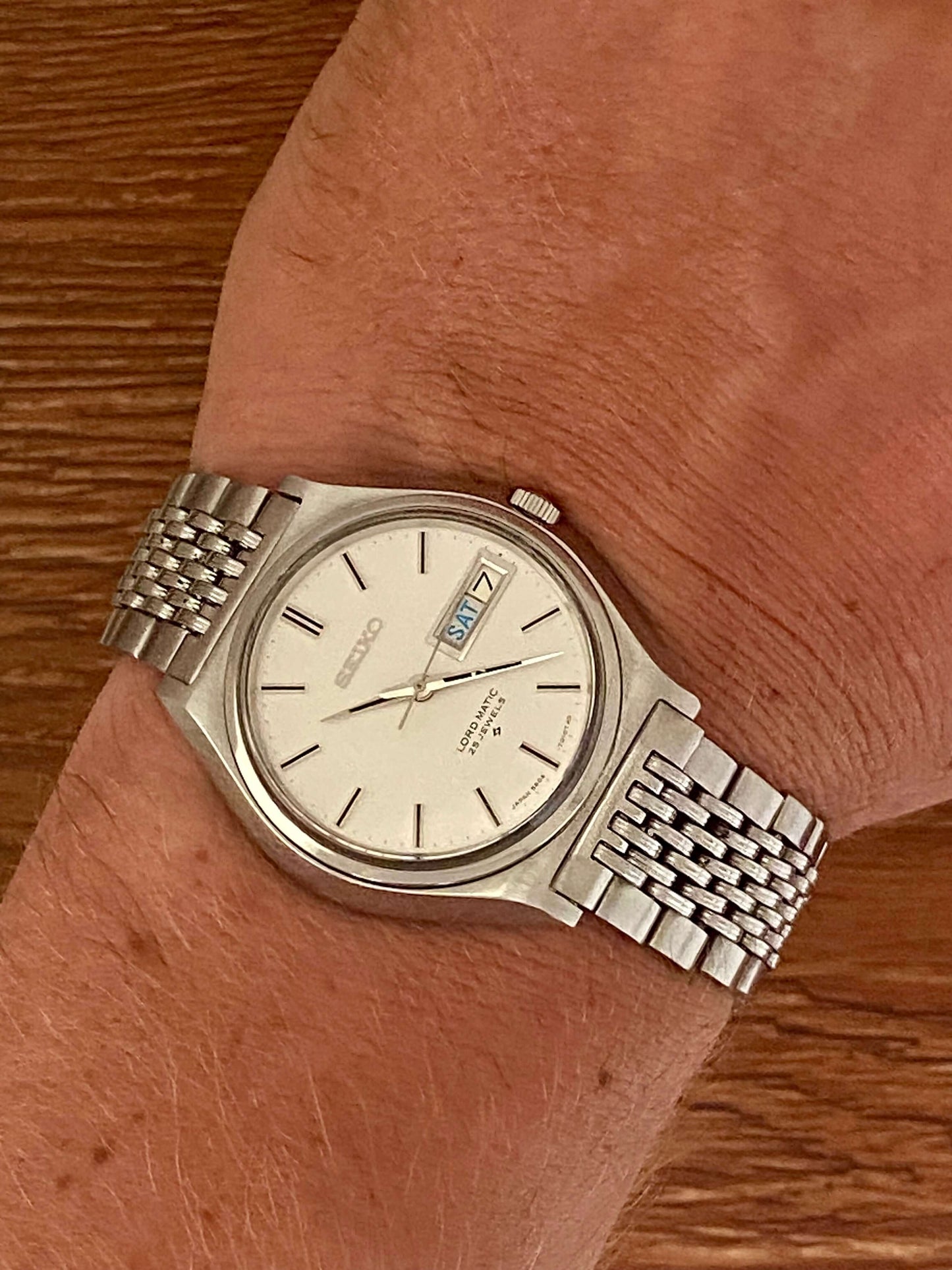 Vintage Seiko Lord Matic 5606-7010 watch on wrist showing original white linen dial and bracelet.