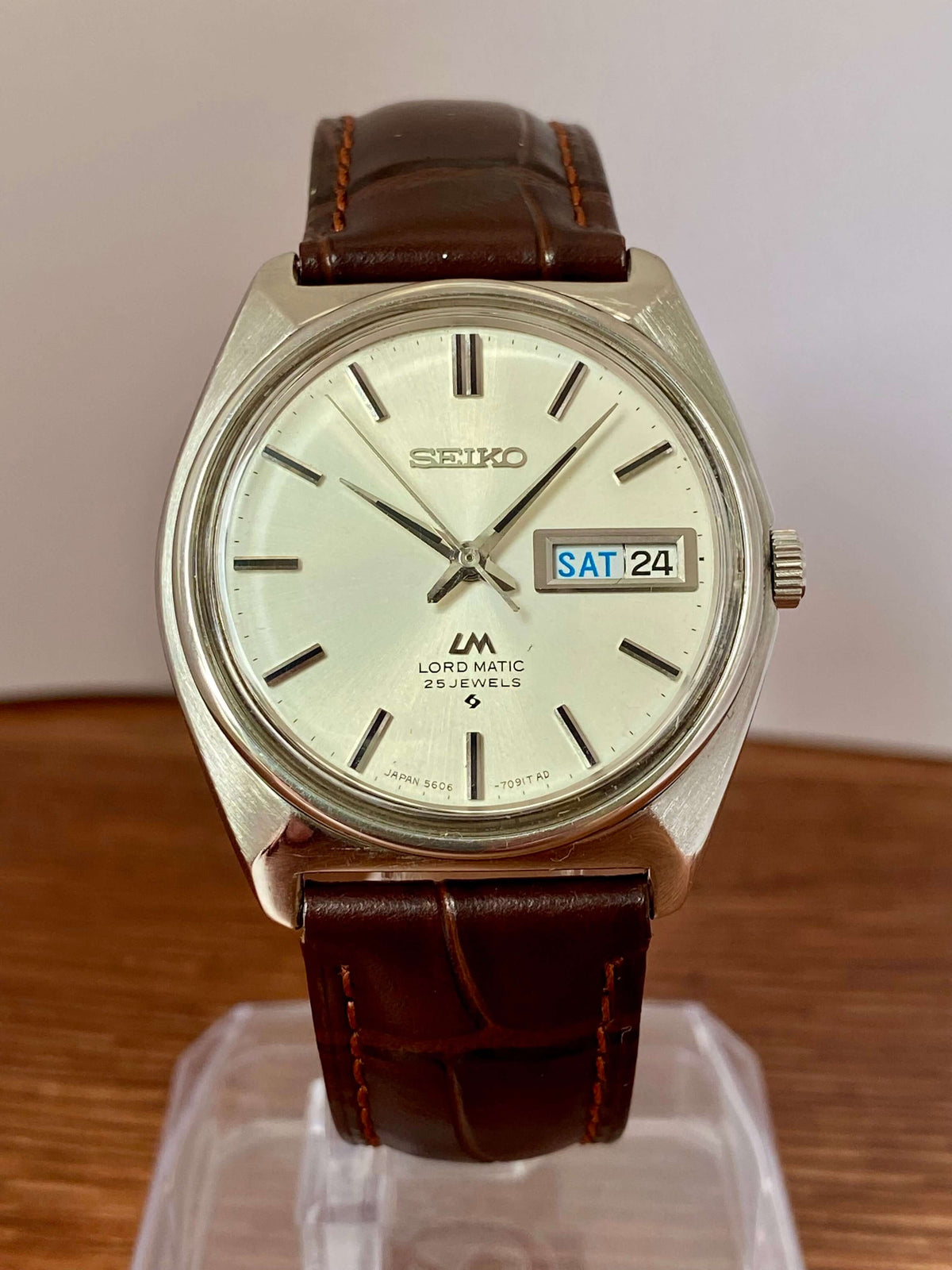 Vintage Seiko Lord Matic 5606-7000 with brown leather strap and bilingual day-date feature.