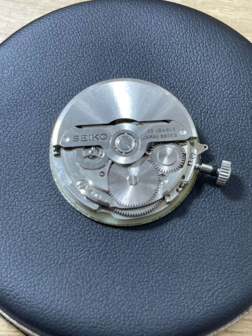 Vintage Seiko Lord Matic 5606-7000 watch movement close-up, showing gears and mechanics on a black background.